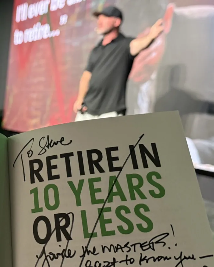Ryan Lee on stage behind his signed book
